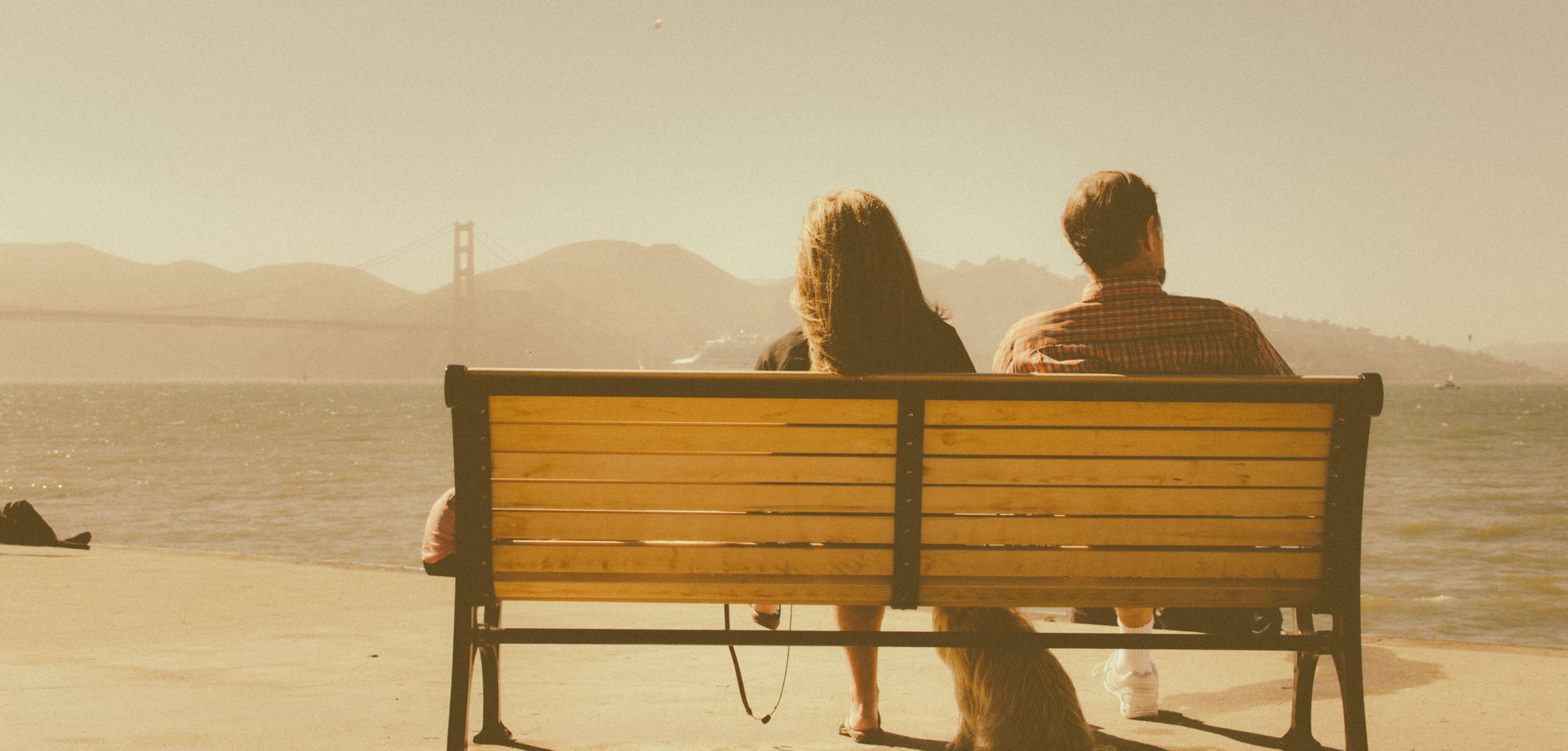 Happy, complaint-free couple sitting on bench at San Francisco bay